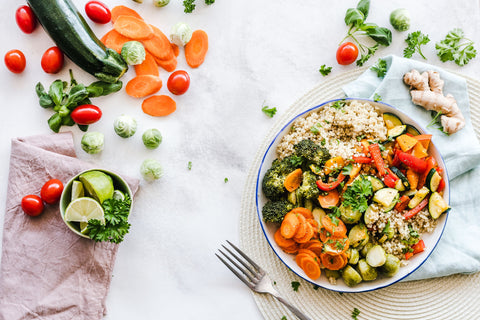 Vegan quinoa bowl with roasted broccoli, carrots, zucchini and peppers
