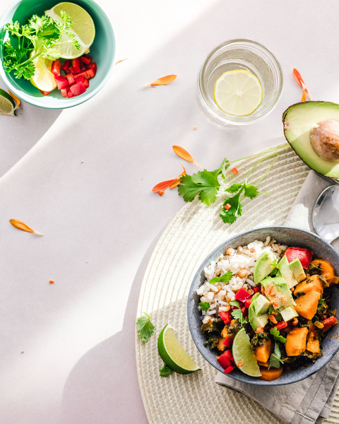 Vegan nourish bowl with rice, roasted vegetables, avocado and lime