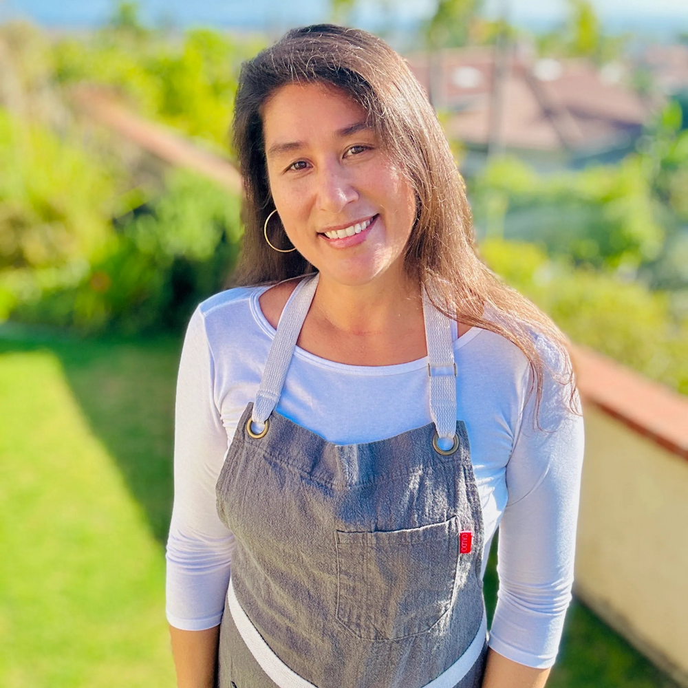 Sharon King, founder of The SoCal Vegan, smiling outdoors while wearing a gray apron.