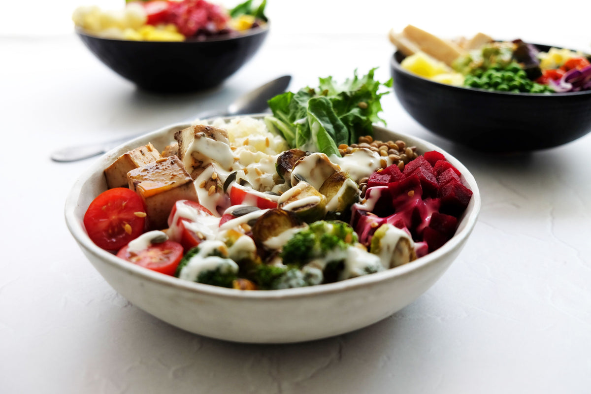Fresh tomato salad with red and yellow cherry tomatoes, red bell pepper, basil and sliced onion in a wooden bowl