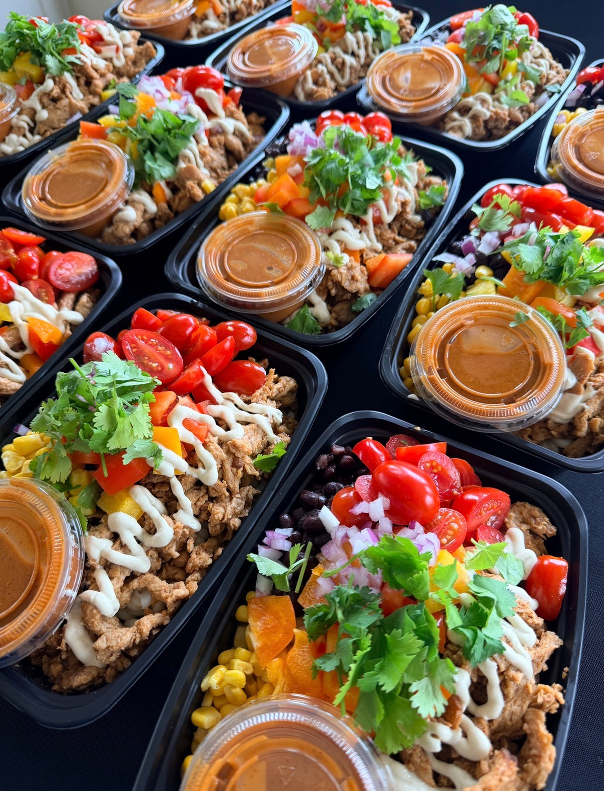Southwest Chik'n Pasta Bowl with spiral pasta, seasoned chik’n (soy curls), black beans, corn, bell pepper, tomatoes, red onion, cilantro, cashew cream, crushed plantain, and chipotle-agave dressing. 