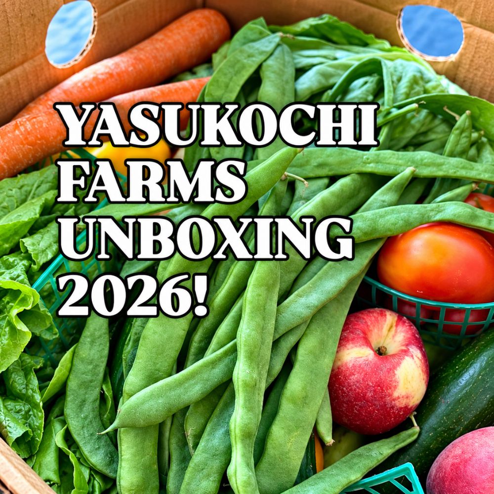 Fresh produce packed in a cardboard box, including green beans, carrots, leafy greens, tomatoes, apples, and zucchini, with text reading ‘Yasukochi Farms Unboxing 2026!’